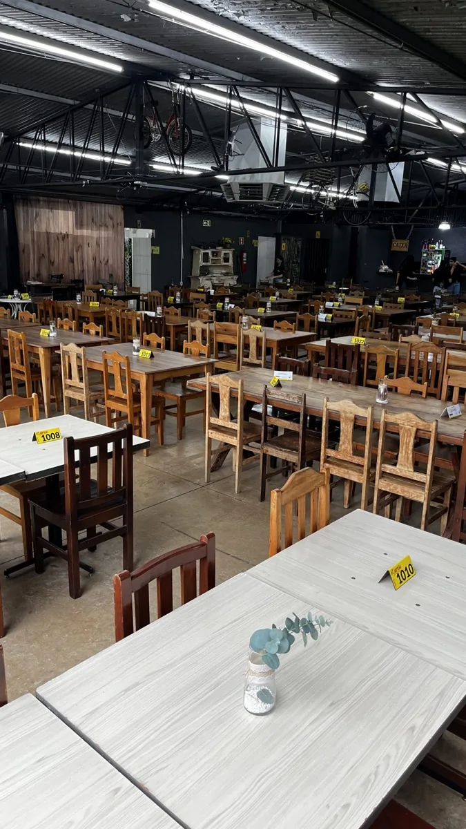 Área do buffet, com mesas e cadeiras de madeira
